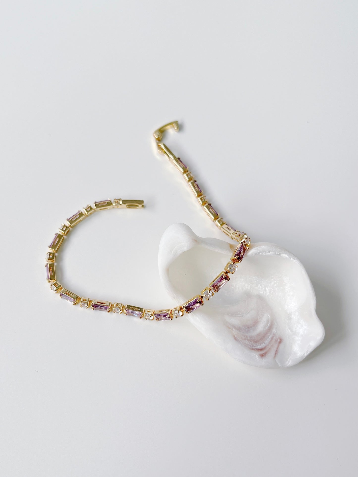 Pulsera bañada en oro con circonitas moradas y transparentes